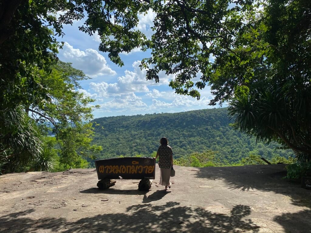 Scenic view of a traveller looking over the lush green mountains and vast landscapes of the Isan region in northeastern Thailand.