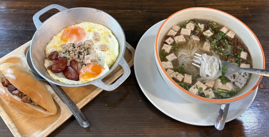 Traditional pan-fried morning eggs served with a fresh baguette and a clean bowl of Vietnamese-style noodle soup in Ubon Ratchathani, Isaan.