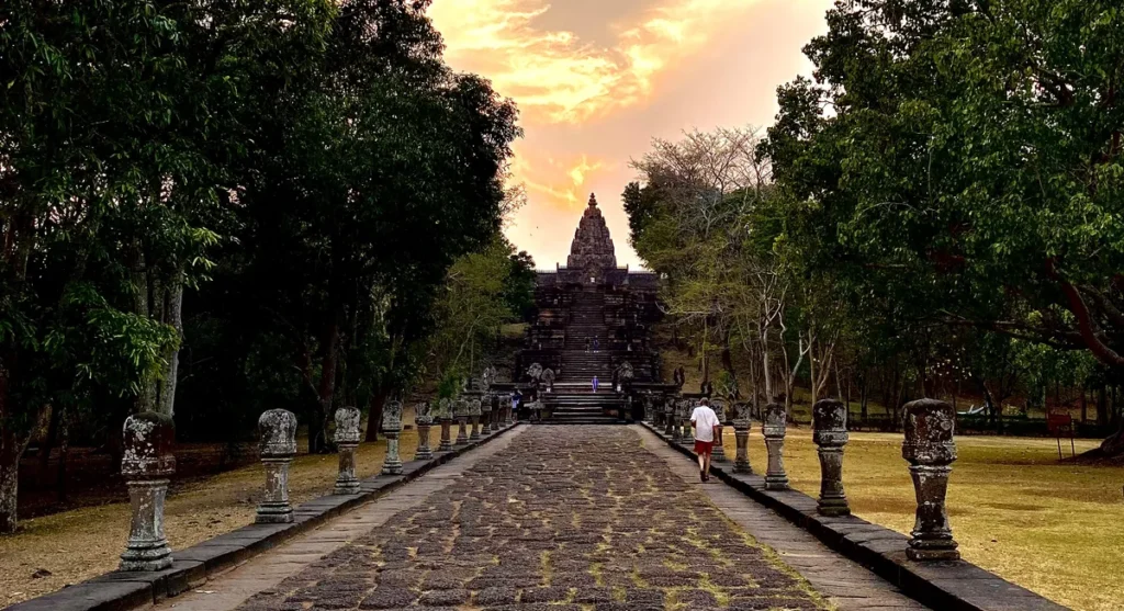 Isaan travel guide photo showing the stone processional walkway and main sanctuary of Phanom Rung historical park during sunset.