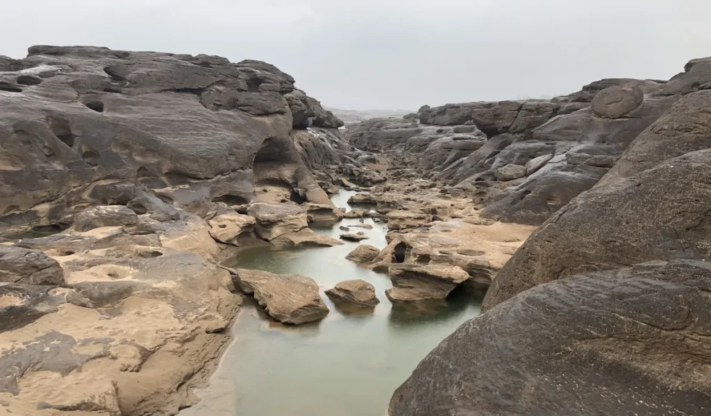 Panoramic view of the eroded sandstone canyon and natural rock pools at Sam Phan Bok along the Mekong River in Ubon Ratchathani Province, Isaan.