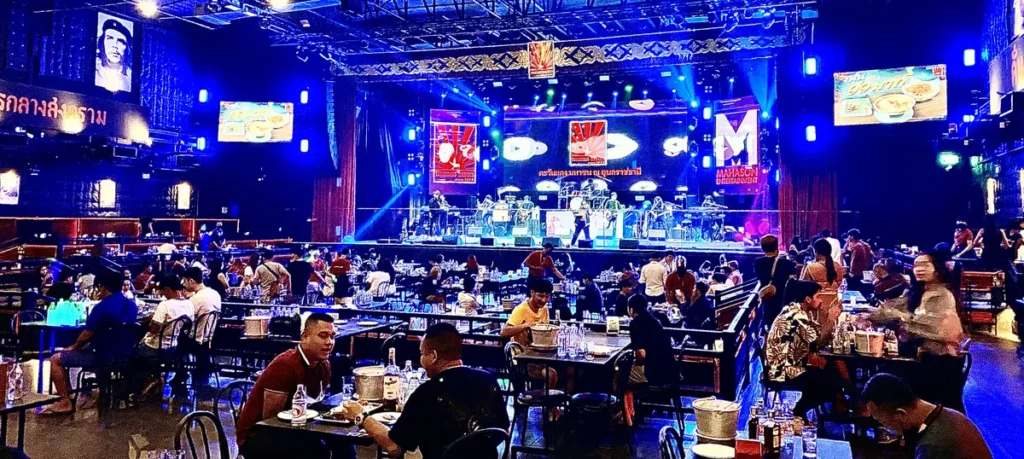 The large indoor stage and packed dining hall with spectators at Tawandang Mahason entertainment venue in Ubon Ratchathani.